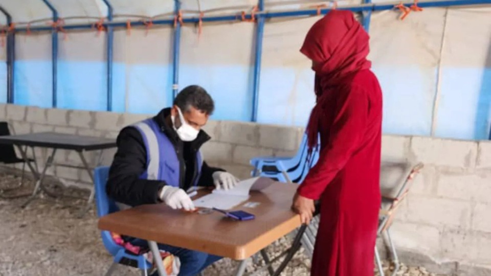 A woman receives humanitarian aid assistance in a camp in northeast Syria. CARE and The Church of Jesus Christ of Latter-day Saints are working together to provide winter clothing and kits for displaced people in 2023. CARE
